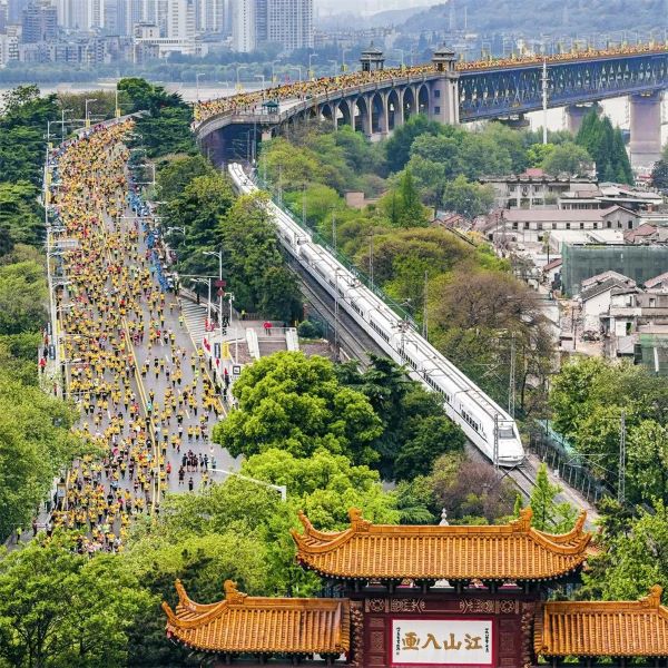 齐头并进 姜涛 摄2019年4月14日，参加马拉松比赛的选手们经过武汉长江大桥，与动车同行，与黄鹤楼同框。.jpg